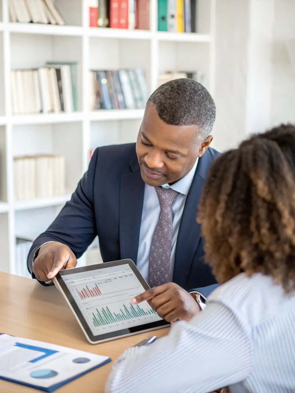 A modern office setting with a financial advisor consulting a client, discussing investment options and strategies in South Africa.
